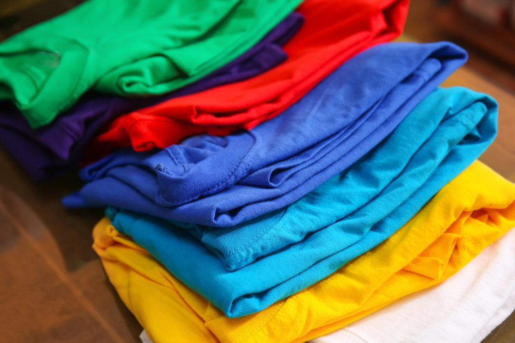 Stack of colorful, folded t-shirts.